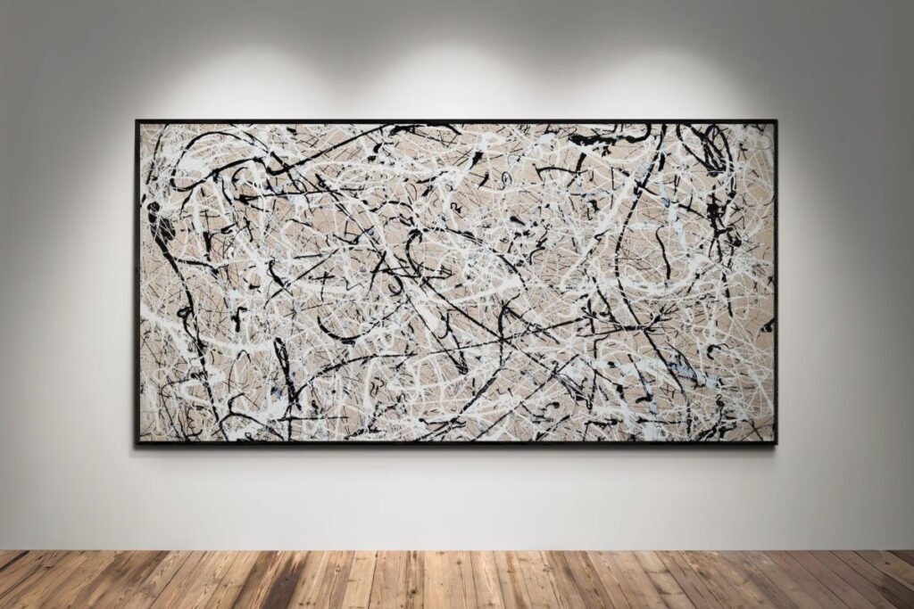 Obra abstracta estilo Jackson Pollock en tonos beige, blanco y negro, colgada en pared blanca con focos de luz