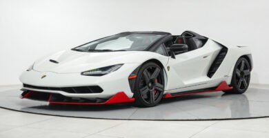 Vista en ángulo delantera del Lamborghini Centenario Roadster, destacando su aerodinámica y diseño exclusivo en blanco con rojo.