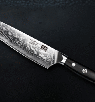 Cuchillo japonés SHAN ZU de acero Damasco con hoja de 67 capas y mango negro ergonómico, sobre fondo oscuro