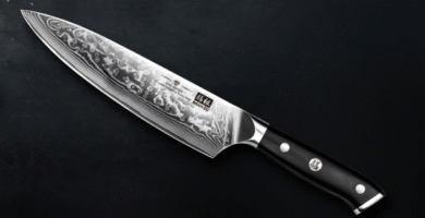 Cuchillo japonés SHAN ZU de acero Damasco con hoja de 67 capas y mango negro ergonómico, sobre fondo oscuro