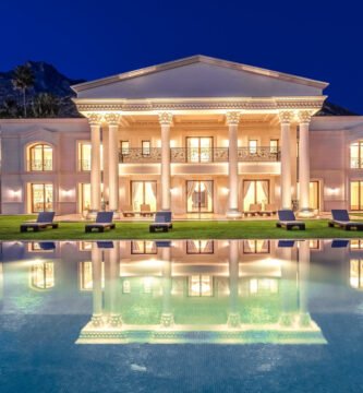 Fachada iluminada de Villa Bellagio en Marbella, con piscina infinita y arquitectura clásica inspirada en palacios europeos.