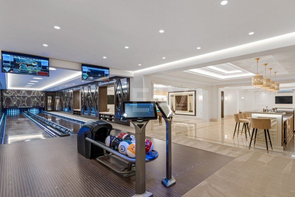 ala de entretenimiento en Villa Bellagio con bolera privada, pantallas interactivas y bar de lujo integrado.