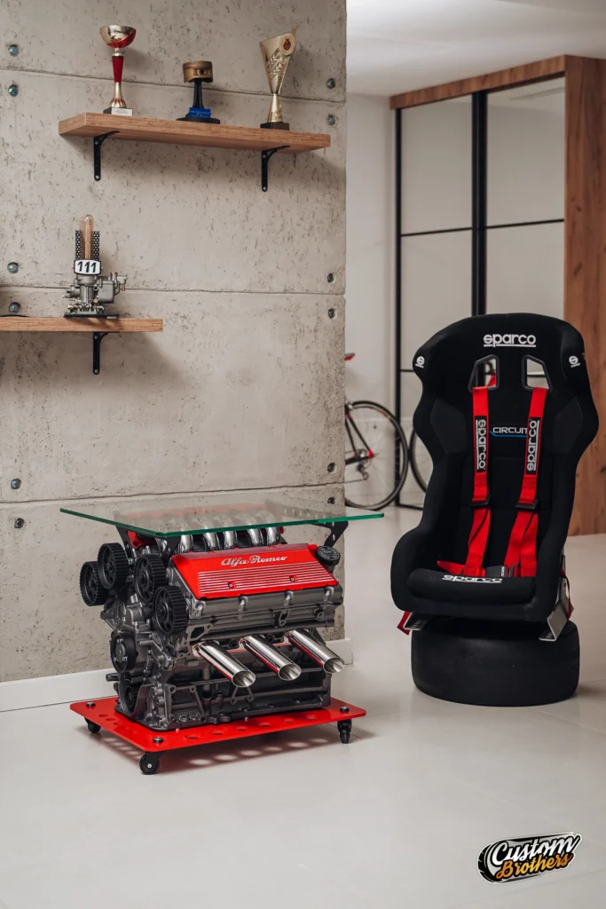 Mesa con motor Alfa Romeo y silla de competición Sparco en interior decorado con estilo racing