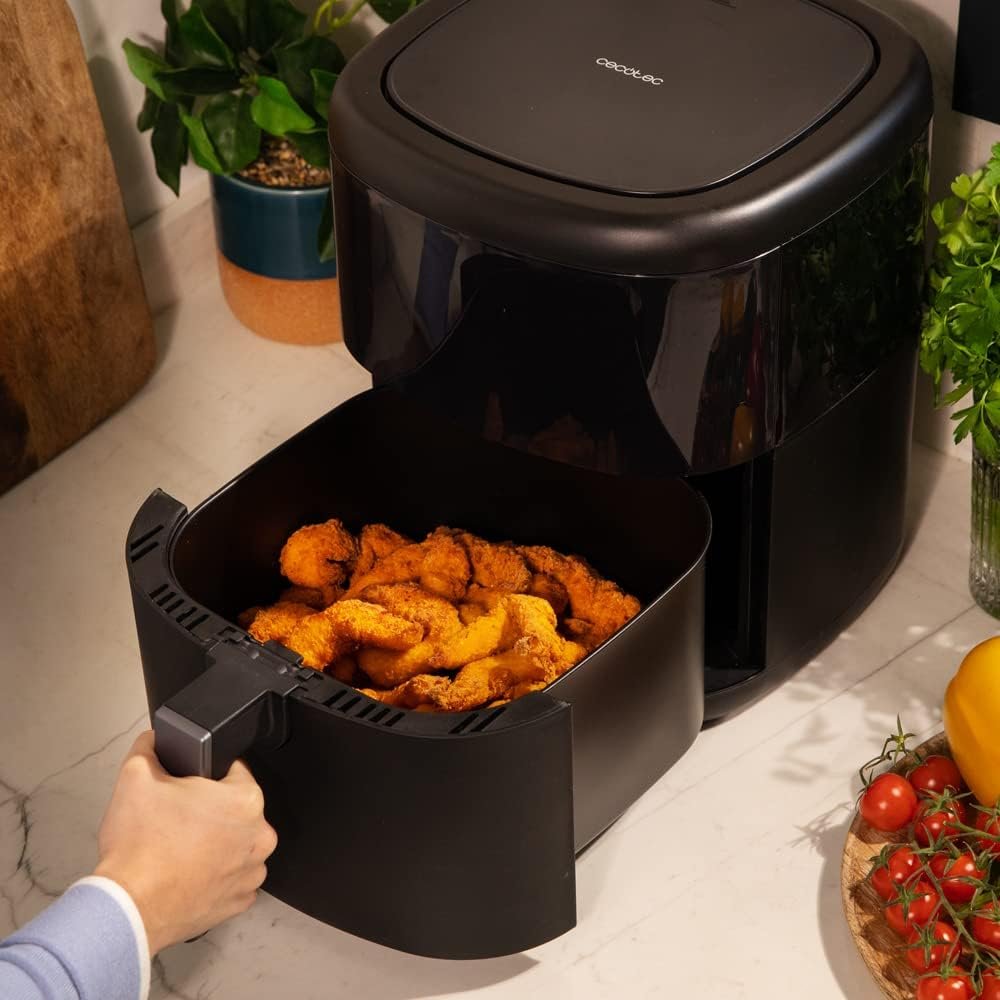 Bandeja de la freidora Cecotec Cecofry Advance 5000 abierta con alitas de pollo cocinadas y listas para servir