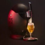 Grifo Huebox con diseño esférico negro tirando una cerveza Estrella Galicia bajo una luz tenue y elegante