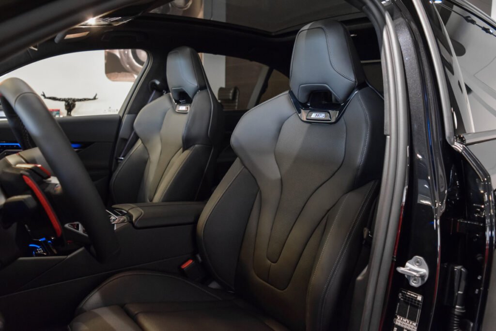 Interior del BMW M5 mostrando los asientos deportivos M multifunción en cuero negro.